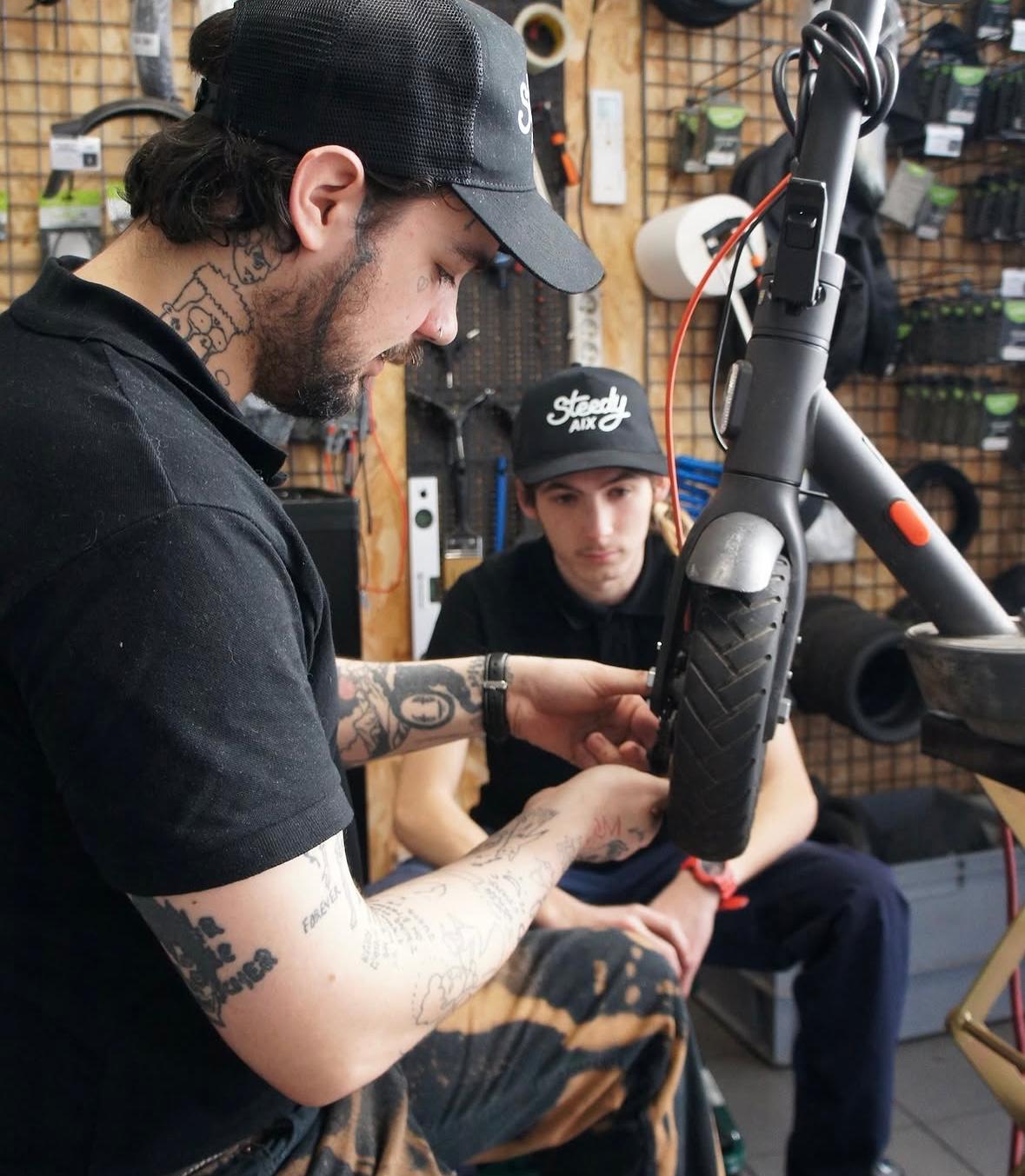 Techniciens Steedy en duo sur une trottinette